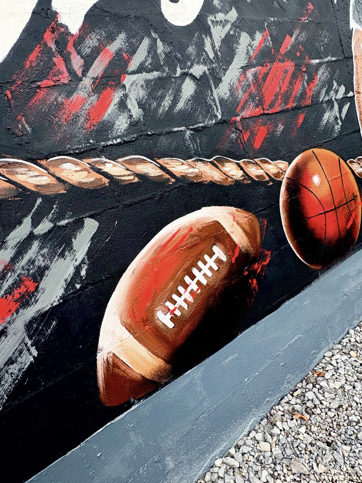 Detail of football and basketball elements in the gym mural