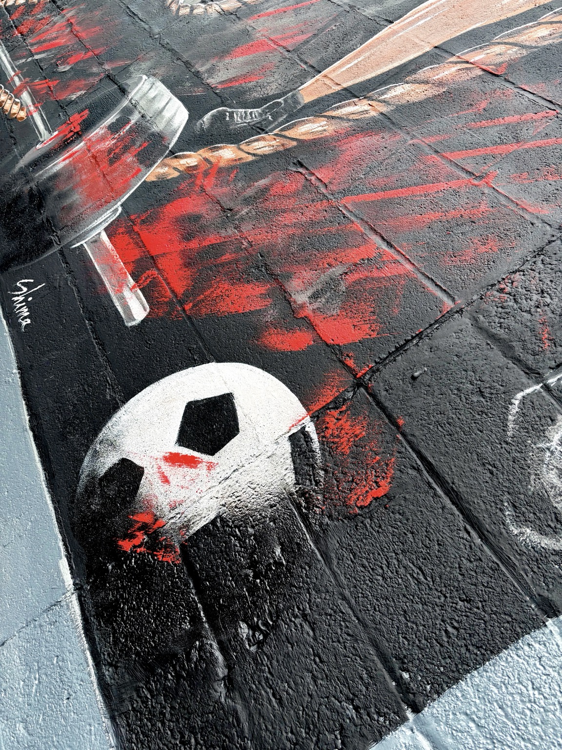 Detail of soccer ball and red movement marks in the mural