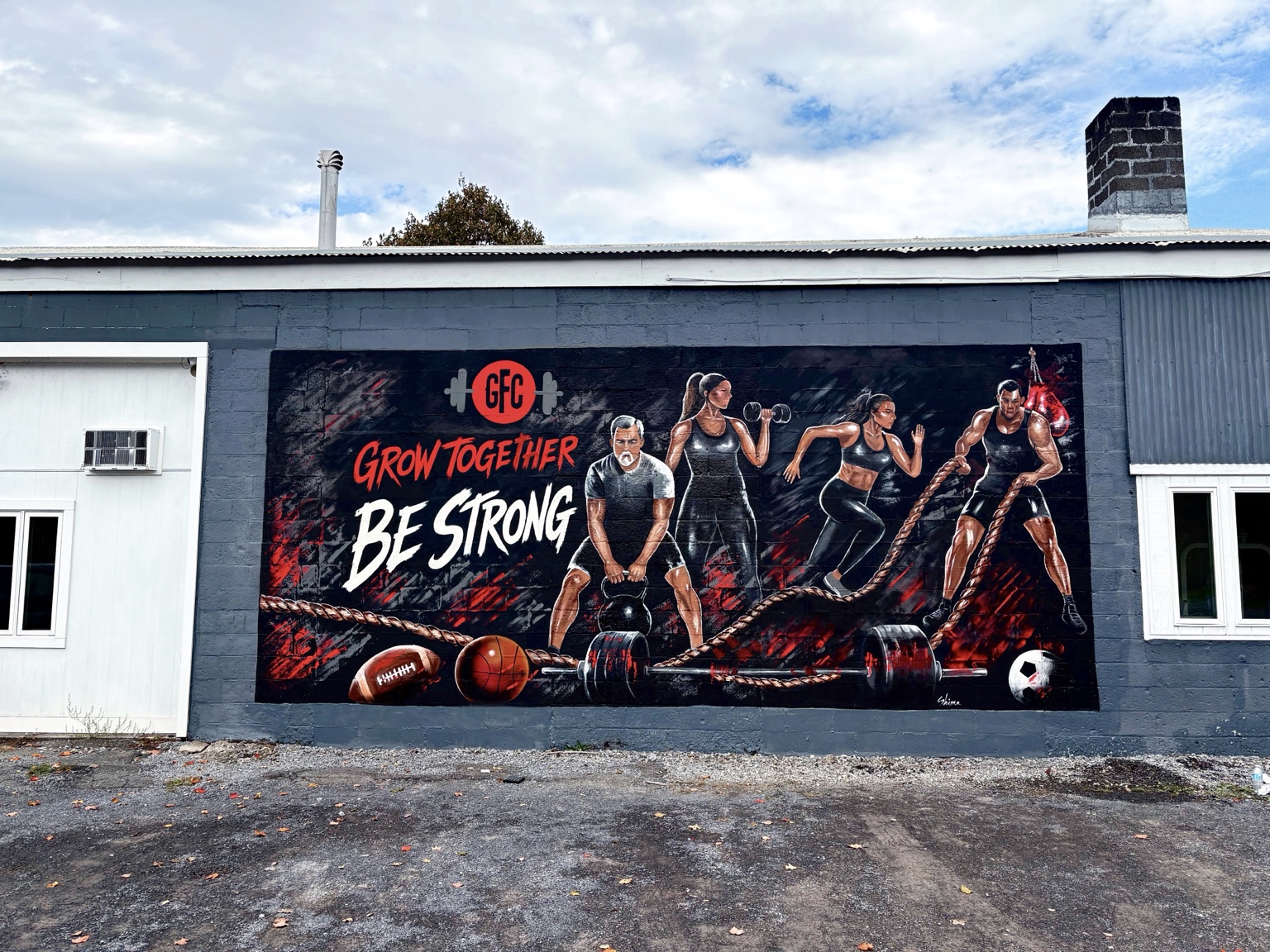 Full view of the Grow Together mural on the gym exterior